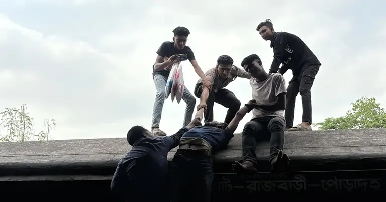 ট্রেনের ছাদ থেকে মরদেহ নামানো হচ্ছে